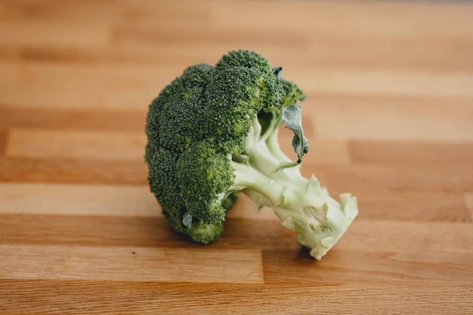 fresh broccoli on brown wooden table